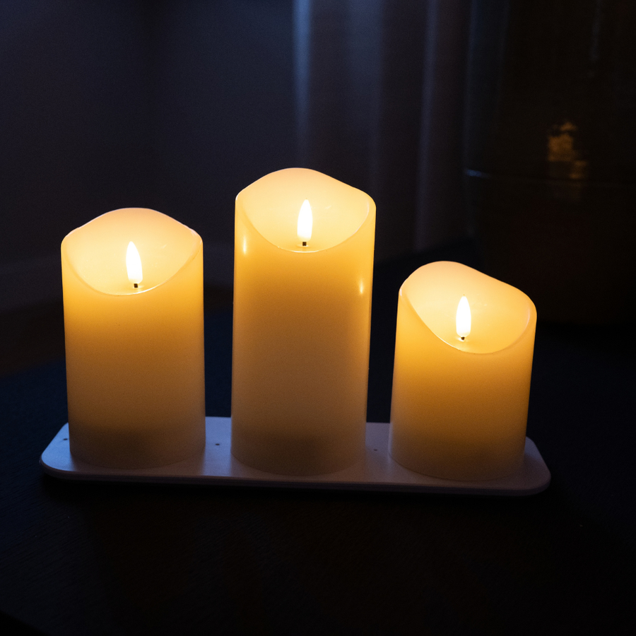 Drie Akaro LED kaarsen in oplopende hoogtes op hun oplaadstation