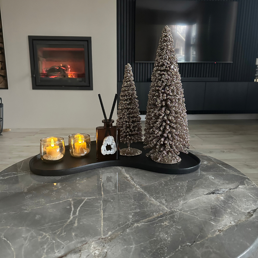 Twee Akaro waxinelichtjes op een dienblad met kerstdecoratie, open haard op de achtergrond