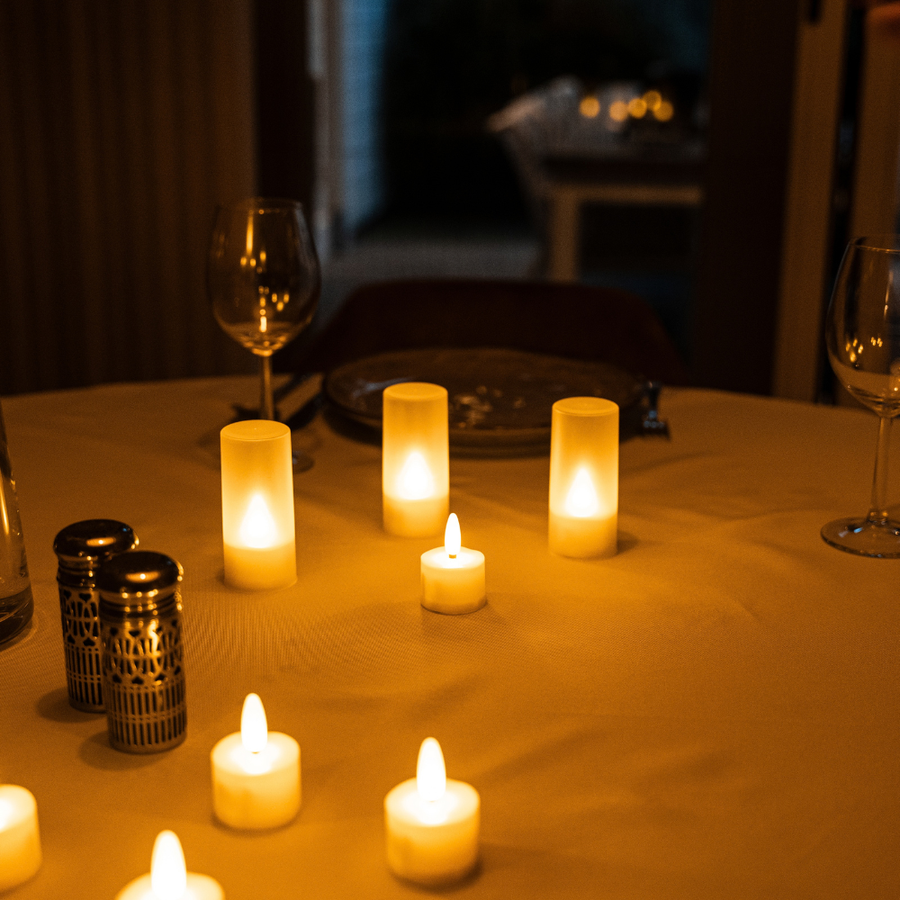 Gedekte tafel met wijnglazen en Akaro waxinelichtjes, deels in hun kokers